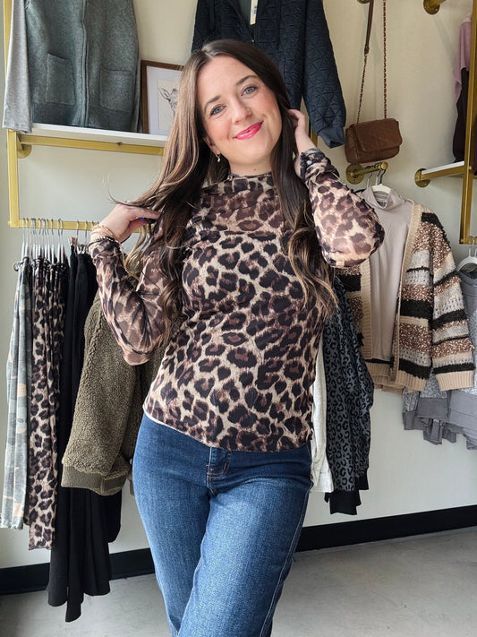 Unleash your wild side with this Leopard Ruffle Trim Mesh Top! Featuring a sheer mesh fabric with bold leopard print and playful ruffle detailing along the sleeves and hem, this long-sleeved top adds a flirty edge to any outfit. Perfect for layering or wearing solo, it brings effortless style and a touch of fierce fun to your wardrobe.

Bibi