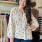 This Oatmeal Dainty Floral Blouse features lightweight linen fabric that drapes elegantly, complemented by flowing balloon sleeves for a refined silhouette. The tie neck detail adds a classic touch, while the cinched cuffs provide subtle structure and shape to the sleeves. Ideal for versatile styling, this blouse blends comfort with sophisticated design.

Bibi