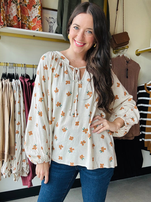This Oatmeal Dainty Floral Blouse features lightweight linen fabric that drapes elegantly, complemented by flowing balloon sleeves for a refined silhouette. The tie neck detail adds a classic touch, while the cinched cuffs provide subtle structure and shape to the sleeves. Ideal for versatile styling, this blouse blends comfort with sophisticated design.

Bibi