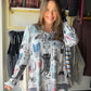 A little feline personality for laid-back days. The Lounging Cats V Neck by Creations pairs a playful cat print with an easy long-sleeve silhouette. Wear it with jeans for coffee runs, or tuck it under a jacket when the day calls for another layer.

Details to love

Cat-print design for a cheerful, casual look.
V neckline and long sleeves.
Relaxed fit, according to the existing product details.
95% polyester, 5% spandex.
Styling &amp; sizing

Pair with denim and sneakers for an effortless outfit, or layer u