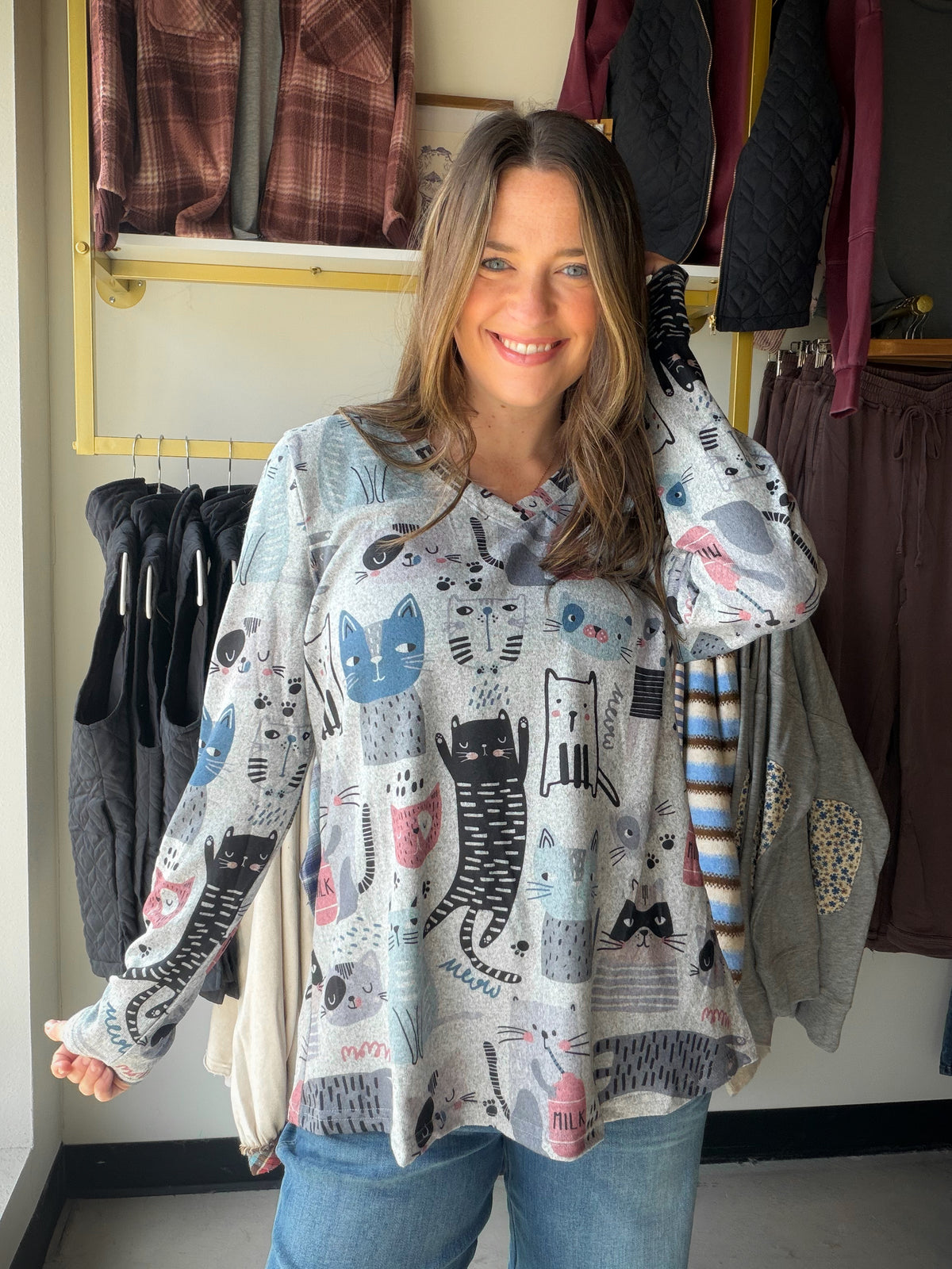 A little feline personality for laid-back days. The Lounging Cats V Neck by Creations pairs a playful cat print with an easy long-sleeve silhouette. Wear it with jeans for coffee runs, or tuck it under a jacket when the day calls for another layer.

Details to love

Cat-print design for a cheerful, casual look.
V neckline and long sleeves.
Relaxed fit, according to the existing product details.
95% polyester, 5% spandex.
Styling &amp; sizing

Pair with denim and sneakers for an effortless outfit, or layer u
