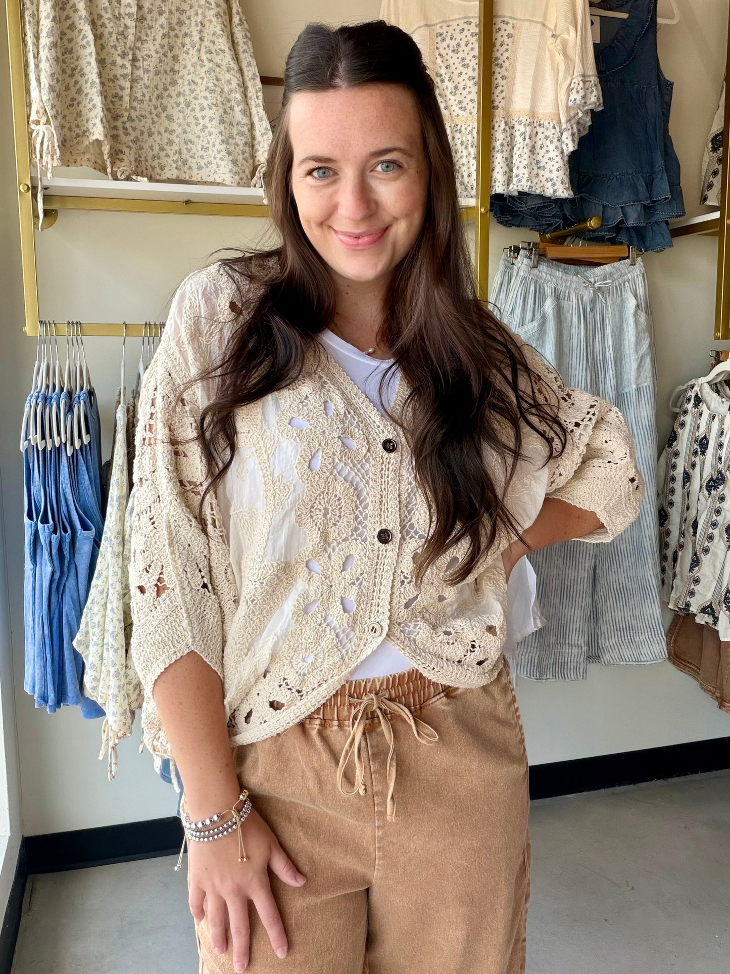 The layer you didn't know you needed. The Natural Batwing Crochet Cardigan brings that effortless, throw-it-on energy with a relaxed batwing silhouette and delicate crochet craftsmanship that feels anything but casual.

A V-neckline and button-down front keep it versatile — wear it open as a breezy layer over your favorite summer dress, or buttoned up as a standalone top. The high-low hem adds a modern touch, and the airy cotton-blend crochet makes it the kind of piece you'll reach for on repeat all season 