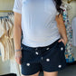 Sunday Edition

Elevate your loungewear with these navy sweatshorts adorned with a charming white daisy embroidery. The adjustable drawstring waistband ensures a perfect fit, while the soft fabric keeps you comfortable all day long. Pair them with the matching crewneck sweatshirt to complete a coordinated set that's effortlessly stylish. Ideal for relaxing at home or running errands in comfort.
