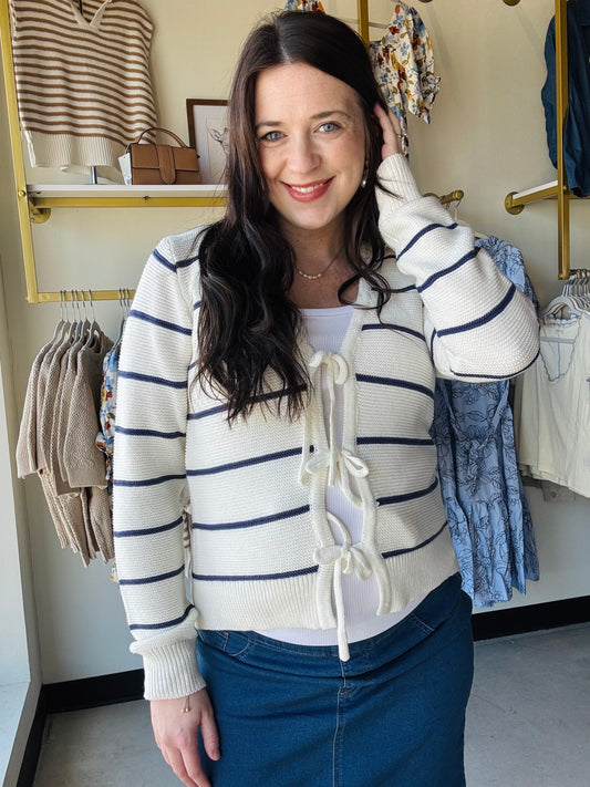 This navy striped cardigan combines timeless style with modern details. The decorative bow tie at the front and V-neckline add personality, while long sleeves and quality construction make it a reliable layering piece. Wear it over dresses, tees, or as a standalone top for effortless sophistication that transitions seamlessly from day to evening.