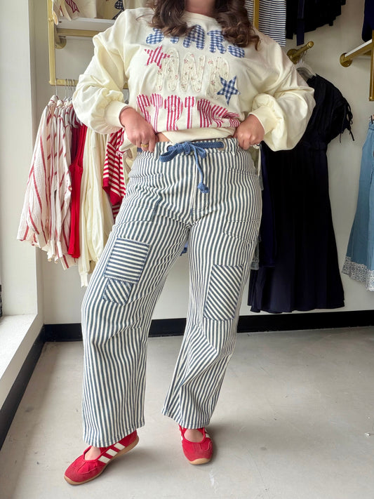 Bibi

These versatile barrel pants feature a classic navy and white stripe pattern in durable twill fabric. The relaxed, tapered silhouette offers modern comfort with an adjustable drawstring waistband for a customized fit. Perfect for casual outings or dressed-up occasions, these pants transition seamlessly from day to night. The striped design adds visual interest while remaining easy to style with your favorite tops and accessories.

