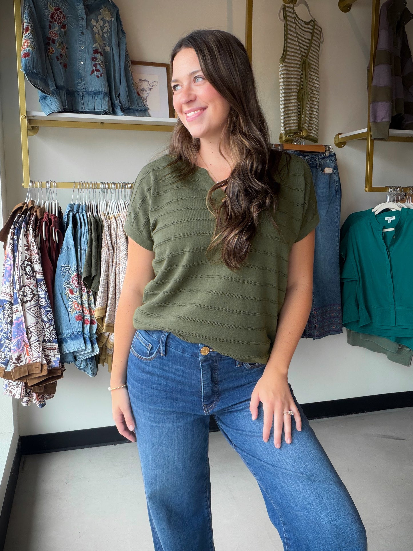 The&nbsp;Olive Pointelle Stripe Sweater by Staccato is a warm-weather knit done right. Delicate pointelle striping adds beautiful texture and visual interest, while the Y-split half-button neckline brings a playful, feminine touch to a classic silhouette.

Made from 100% Cotton, this short sleeve sweater is breathable and lightweight — perfect for layering into fall or wearing solo on a breezy day. The rich olive hue pairs effortlessly with denim, white trousers, or your favorite skirt.

Pointelle stripe kn