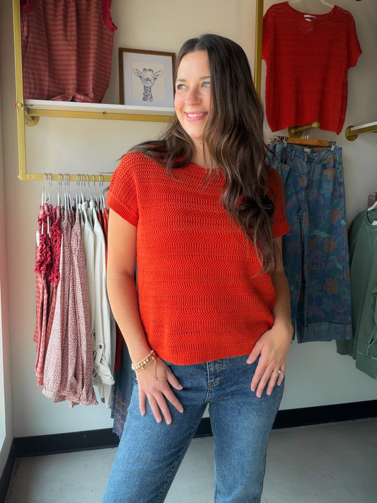 A rich dark orange hue meets delicate pointelle knit in this easy short-sleeve sweater. The wide crew neck and relaxed silhouette make it a versatile layering piece — wear it solo on a cool summer evening or over a collared shirt for a polished, textured look.

Wide crew neckline
Short sleeve silhouette
Pointelle knit texture
100% Cotton — breathable and soft
Relaxed, easy fit