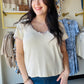 Designed in a V-neck short sleeve regular fit top crafted from soft cotton jersey. Featuring delicate contrast trim along the neckline and sleeve edges, this piece adds a subtle feminine touch to a classic silhouette. Finished with vintage washing for a naturally soft, lived-in feel, the lightweight fabric offers everyday comfort with effortless styling versatility. A timeless solid essential perfect for layering or wearing on its own.