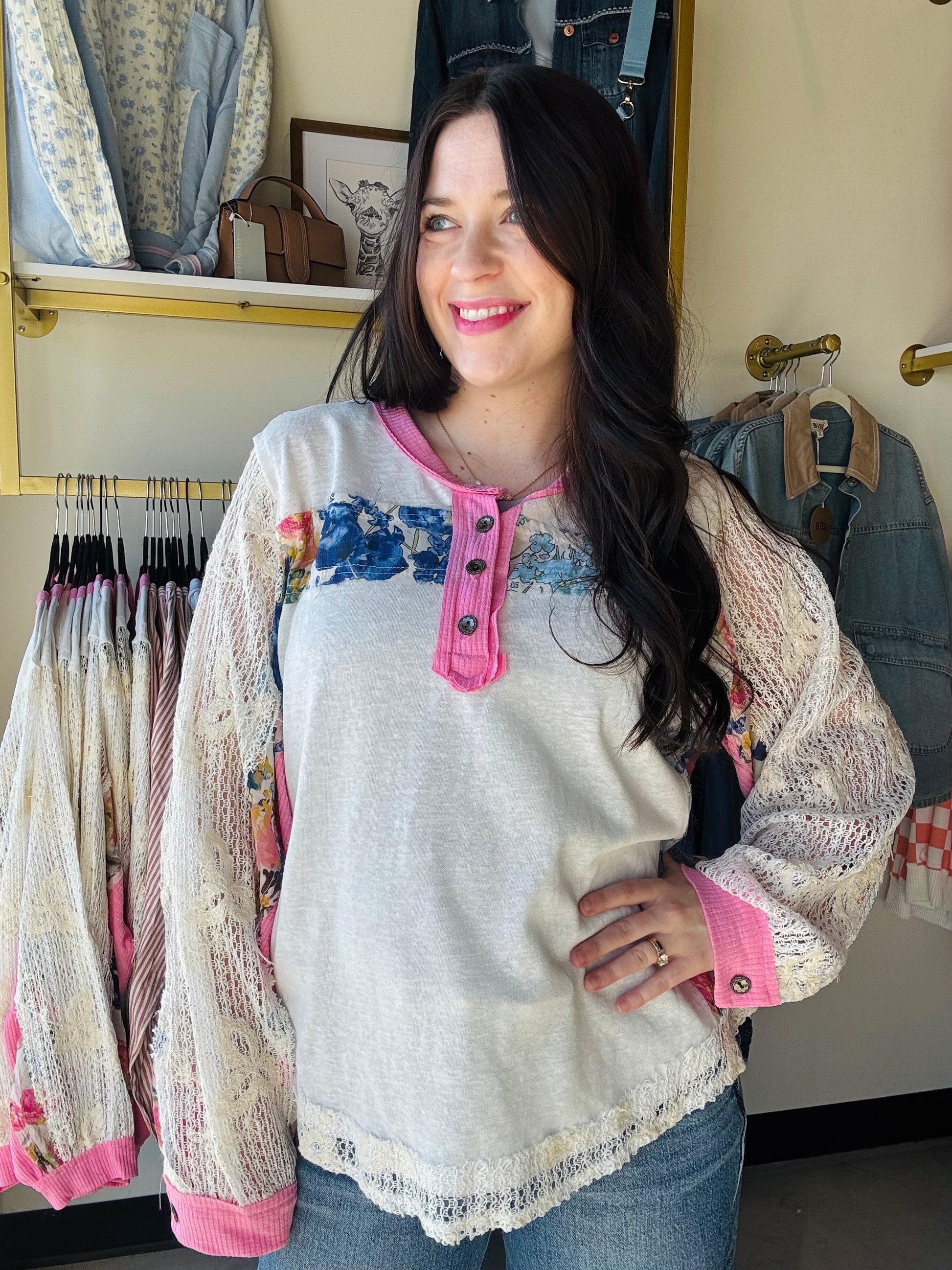 POL

Embrace effortless spring style with this charming lace trim patch top. Delicate lace sleeves and pink accents frame a beautiful floral pattern, while functioning buttons offer easy layering versatility. The oversized silhouette delivers that coveted relaxed fit perfect for casual days and breezy weather. Whimsical details meet everyday comfort in a piece that feels as good as it looks.