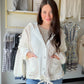 The ultimate cozy-chic layer. The Cream Quilted Thermal Button Up by POL is a wardrobe staple that blurs the line between jacket and sweater — in the best possible way. Featuring a button-down front, oversized fit, and a quilted thermal knit construction with cut-and-sew sweater knit panels, this piece delivers serious texture and warmth without sacrificing style.

The hoodie detail adds a casual, laid-back vibe that pairs effortlessly with denim, leggings, or your favorite wide-leg trousers. Wear it open a