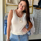 Meet your new warm-weather staple. The Cream Stud Accent Knit Tank is crafted from a soft, lightweight knit blend that moves with you from morning errands to evening plans — no effort required.

A flattering V-neckline and delicate button-front with ruffle detail keep things feminine, while metal stud accents along the neckline add just the right amount of edge. Side slits give you easy, unrestricted movement, and the relaxed silhouette layers beautifully under a blazer or denim jacket — or stands perfectly