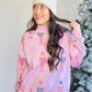 Katydid

With its oversized fit and playful vibe, it pairs perfectly with leggings, fuzzy slippers, and your fave holiday tumbler.Whether you're lounging or lighting up the tree, this sweatshirt brings the festive vibes all season long.