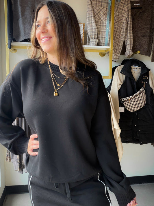 The kind of black pullover you'll want close at hand when the day calls for easy dressing. This Rae Mode crewneck brings a clean, versatile look to coffee runs, casual plans and quiet afternoons. Wear it with denim for an effortless outfit or pair it with your favorite relaxed bottoms.

Details to love

Classic black crewneck style
Pullover sweatshirt silhouette
Available in Small, Medium and Large
Fabric

48% modal, 45% polyester, 7% spandex. Rae Mode style T0123.