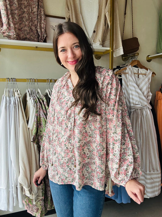 This Slate Rose Floral Blouse features a beautiful V-neck and long sleeves, with a self-tie at the neck for added style. The elastic cuffs provide a comfortable fit, while the lightweight woven material keeps you cool. Perfect for any occasion, this blouse is non-sheer and unlined for a polished look.