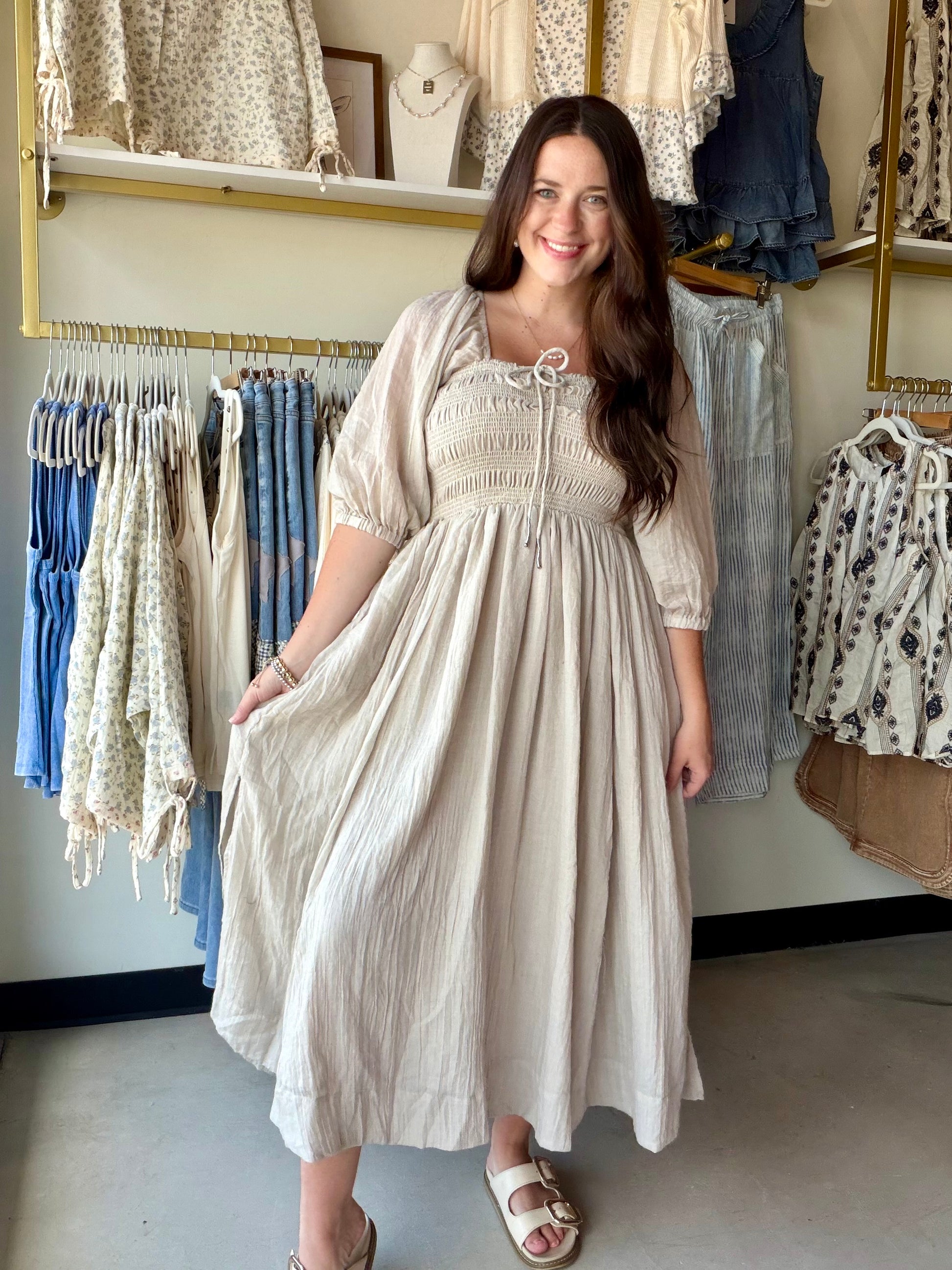 The dress that does the talking. The Natural Smocking Midi Dress is everything a warm-weather dress should be — effortless, feminine, and just a little bit dreamy.

A smocked bodice hugs the body beautifully before flowing into a full, lined midi skirt that moves with you. Volume sleeves and a ruffled neckline bring the romantic detail, while an adjustable tie at the bustline lets you customize the fit to perfection. The flowy cotton-blend fabric keeps it light and breathable all day long.

Dress it up with