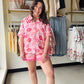 Jess Lea

Elevate your sleepwear game with the Spotted in Bloom Ruffle Pajama Set. The long-sleeve top showcases a captivating blend of pink blooms and leopard spots, finished with a polished collar and practical chest pocket. Shorts feature playful ruffled hems and a sweet bow detail that adds instant charm. Whether you're settling in for a restful night or lounging through lazy mornings, this set delivers the perfect balance of snug and sassy—because your pajamas deserve to be just as fabulous as you are.