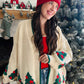Wrap yourself in holiday cheer with this charming cream cardigan featuring festive Christmas trees adorned with twinkling stars. The playful design is elevated by crisp green trim detailing that frames the neckline and cuffs, while cozy ribbed fabric throughout adds texture and comfort. Perfect for spreading seasonal joy whether you're decorating, gathering with loved ones, or simply embracing the festive spirit in style. A wardrobe essential that brings warmth and whimsy to your holiday rotation.

Fantasti