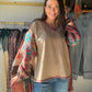 The Mixed Media Tapestry Pullover by Easel brings an artful twist to your everyday wardrobe. Floral tapestry-print panels meet contrasting plaid sleeves, while a mineral-washed finish gives the knit a lived-in look. It’s a statement piece for those days when you want your outfit to feel creative without overthinking it.

A V-neckline and dropped shoulders complement the relaxed, oversized silhouette, and the raw-edge hem adds a casual finishing touch. Picture it with your favorite denim for a coffee date, a