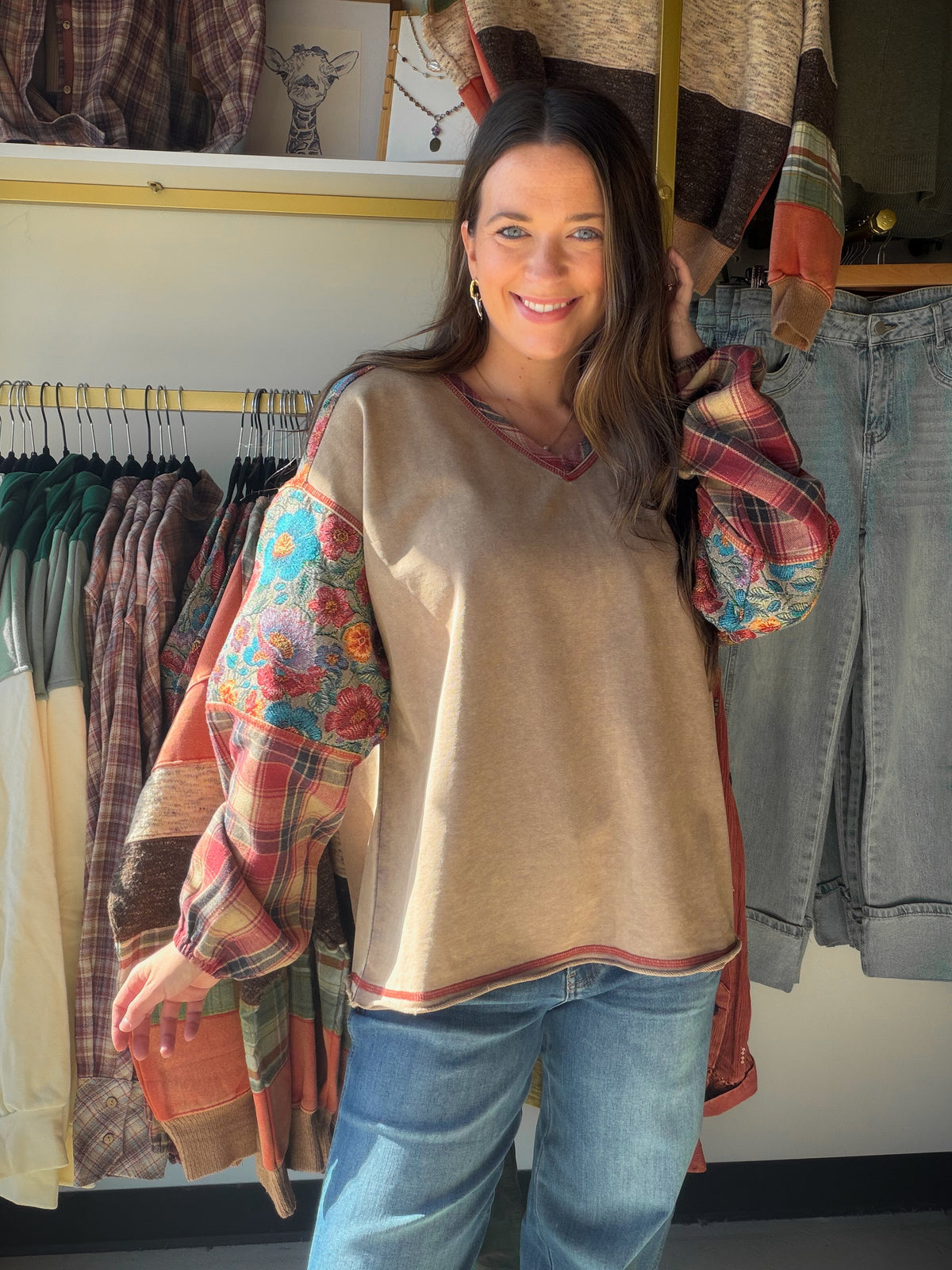 The Mixed Media Tapestry Pullover by Easel brings an artful twist to your everyday wardrobe. Floral tapestry-print panels meet contrasting plaid sleeves, while a mineral-washed finish gives the knit a lived-in look. It’s a statement piece for those days when you want your outfit to feel creative without overthinking it.

A V-neckline and dropped shoulders complement the relaxed, oversized silhouette, and the raw-edge hem adds a casual finishing touch. Picture it with your favorite denim for a coffee date, a