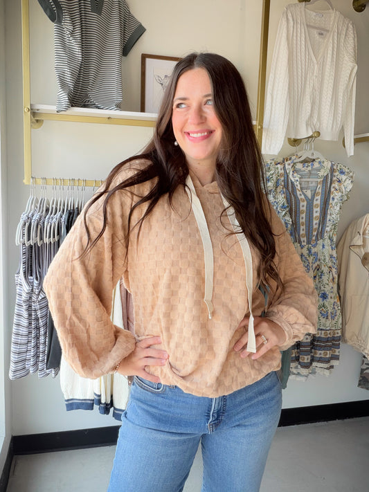 Texture meets comfort in the Taupe Checker Knit Hoodie by Bibi. Crafted in a soft brushed checkerboard knit, this hoodie top brings a playful pattern and cozy feel together in one effortlessly stylish piece. The balloon sleeves add a fun, fashion-forward volume that elevates it beyond your average hoodie.

In a warm, neutral taupe that pairs with everything in your wardrobe, this is the kind of top you throw on and instantly look put-together. Perfect for casual days, weekend outings, or layering into the c