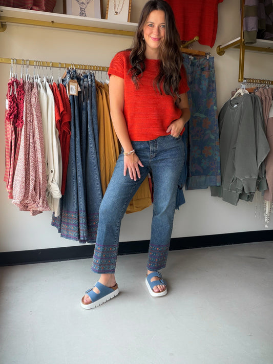 The details make the difference. The Embroidered Hem Kick Denim features delicate colorful embroidery along the hem that gives these jeans an artisan, one-of-a-kind feel. A dark indigo wash and flared kick hem nod to retro-modern style, making them the kind of denim you reach for again and again.

Kick crop silhouette with flared hem
Colorful embroidery detail at hem
Dark indigo wash
Cotton/Poly/Rayon/Spandex blend for comfort and stretch
Pairs effortlessly with fitted tees, flowy blouses, or a classic whit