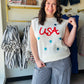 Jess Lea

Shine bright this Independence Day in our festive USA tinsel sweater vest. Featuring bold red textured lettering and shimmering blue sequin stars, this lightweight knit is the ultimate patriotic statement piece for parades, parties, and summer celebrations.

Shimmering blue sequin star accents
Bold red tinsel USA lettering
Lightweight knit for summer comfort
Versatile sleeveless layering piece
Perfect for July 4th festivities
Vibrant, photo-ready patriotic style
Soft, breathable premium fabric ble