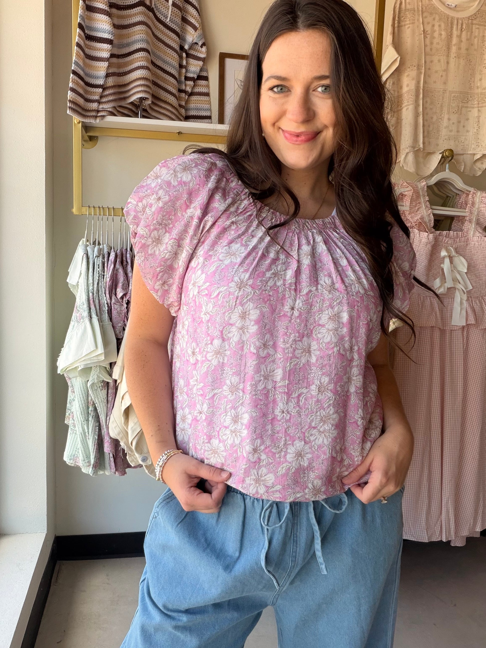 Feminine, flirty, and made for warm-weather dressing — the Pink Floral Puff Sleeve Top by Umgee is the kind of piece that makes getting dressed feel effortless. A vibrant floral print meets a relaxed, flowy silhouette, while short puff sleeves and delicate pleat and gathered details add a romantic, editorial touch. Wear it tucked into your favorite denim or let it flow for an easy, breezy look.

Details:

Floral print throughout
Short puff sleeves with lined construction
Round neckline with gathered detail
