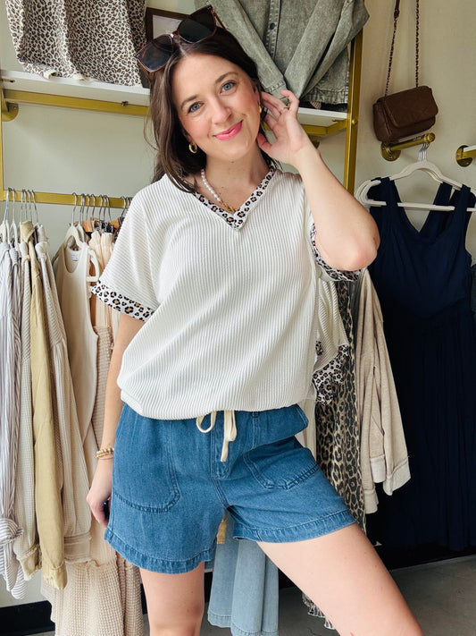 Add a wild twist to your wardrobe with this playful short sleeve top. Crafted from soft rib material, it features a flattering V neckline and eye-catching leopard print trim that brings a fun, fierce vibe to any outfit. Perfect for mixing and matching with your favorite jeans or skirts!
