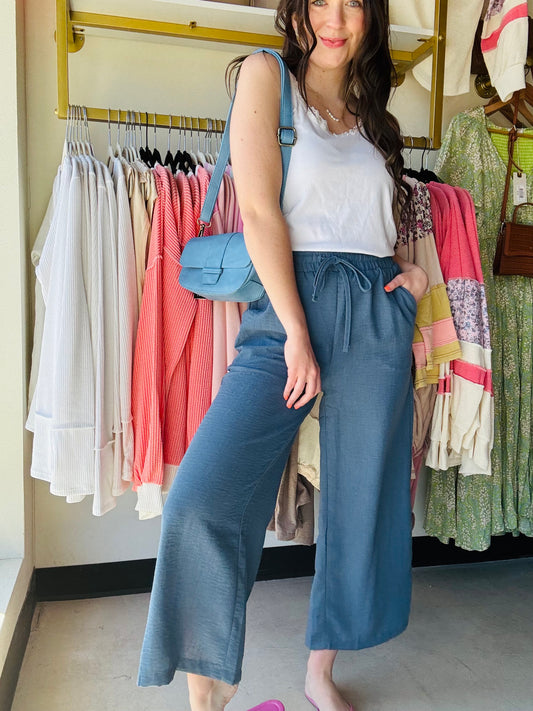 These Dusty Blue Woven Wide Leg Pants are a stylish and comfortable addition to any wardrobe. Made with high quality woven crepe fabric, they feature an elastic band waist and drawstring waistband for a perfect fit. The side pockets add convenience and functionality to these cropped pants. Perfect for any casual or dressy occasion!

size up if between sizes.&nbsp;