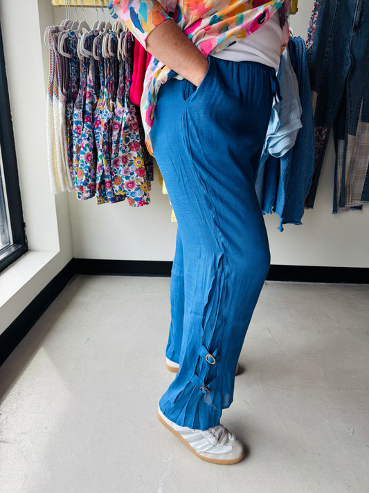 Creations&nbsp;

Lightweight blue crinkle pants designed for warm weather comfort. Features drawstring waist for an adjustable fit and decorative button details along the legs. The breathable fabric keeps you cool during summer months, while the relaxed silhouette offers easy movement. Perfect for casual outings, beach trips, or laid-back days.