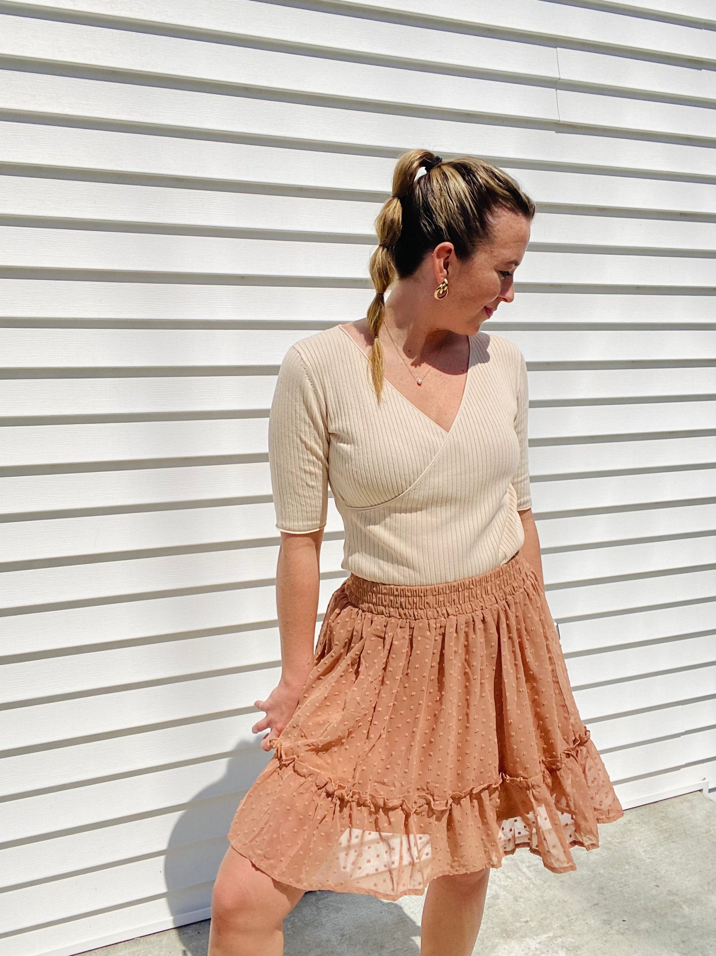 This Apricot Rib Knit Half Sleeve Top easily adapts to any occasion. With its classic style and ribbed fabric, it ensures unbeatable comfort. The unique criss cross hemline provides a unique touch, while its versatile size allows for tucking or leaving it untucked. Enjoy effortless chic style.
