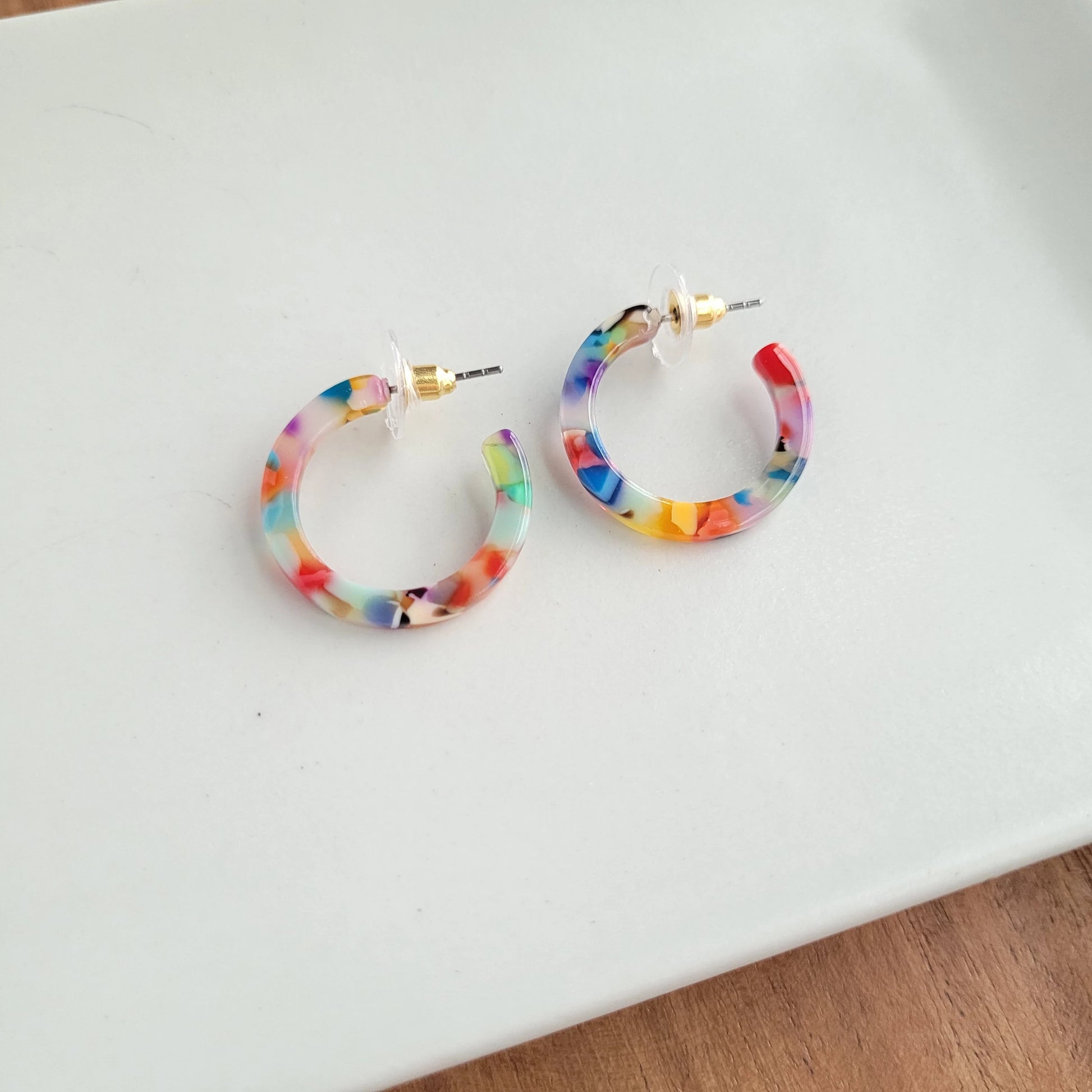 Cam is a mini sized hoop. These ultra lightweight hoops are simple and classic. The perfect versatile piece for everyday wear!  Hypoallergenic stainless steel Lightweight and durable plant-based acetate acrylic 1" diameter Each pair will vary in coloring, making them perfectly unique